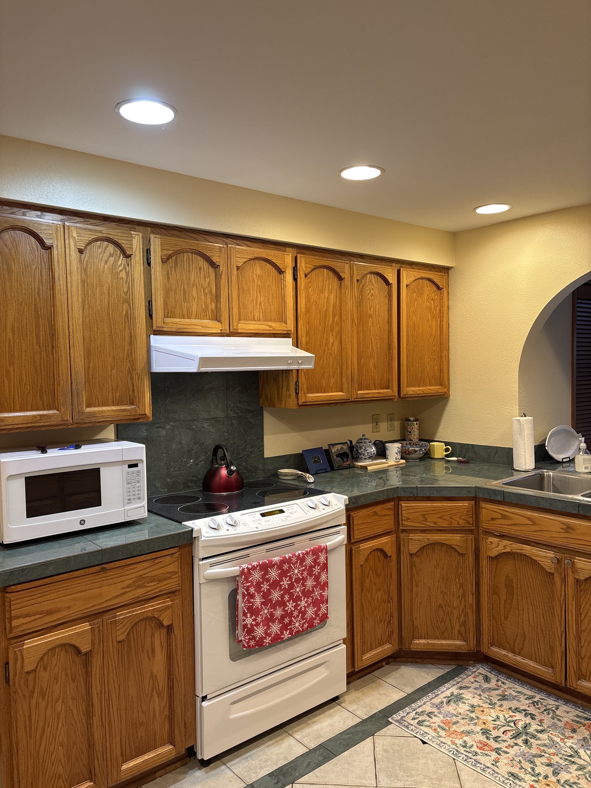 Remodeled kitchen with oak cabinets and a tiled countertop