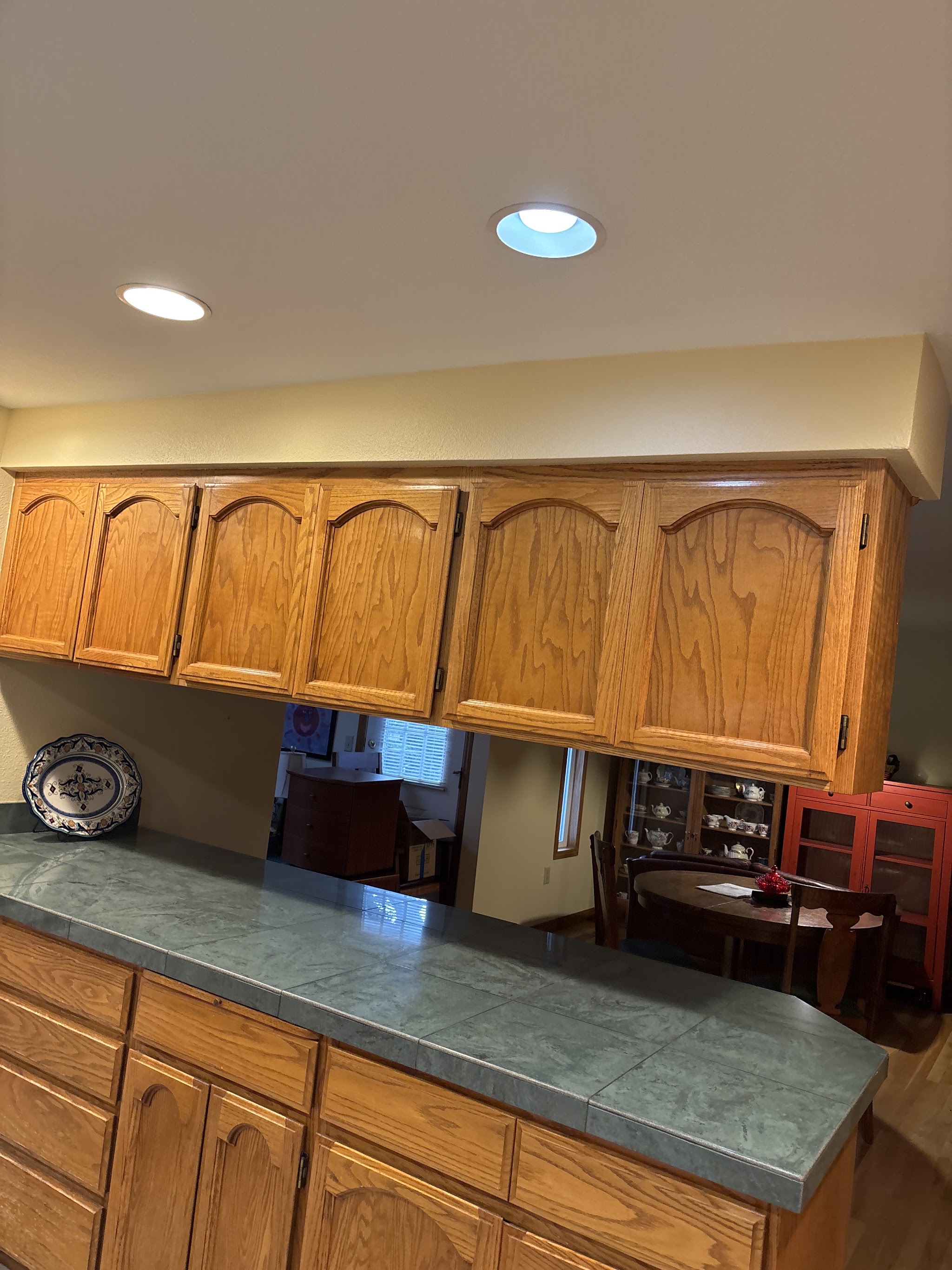 Kitchen pass-through with oak cabinets and a tiled countertop